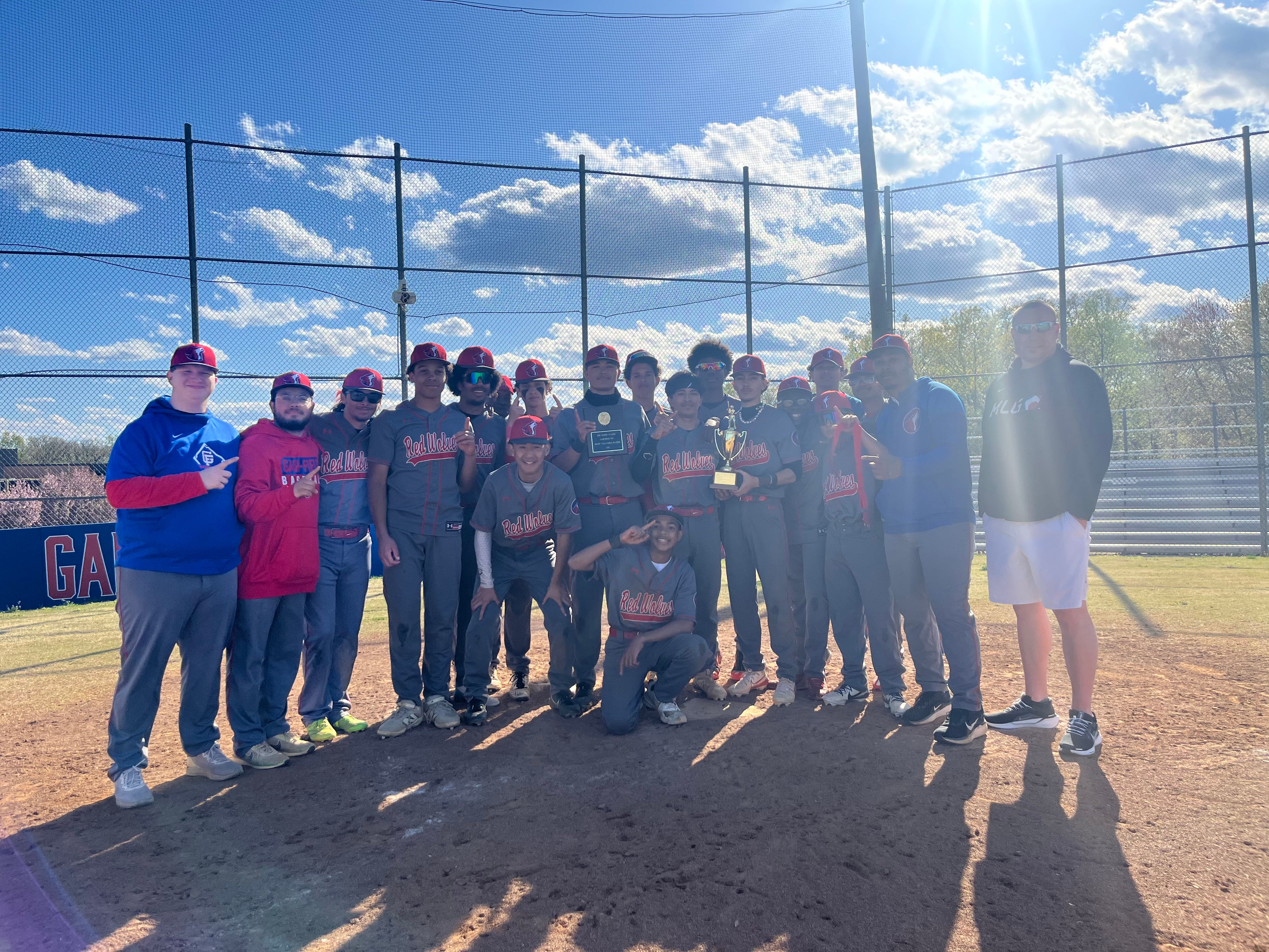 Baseball team picture with Alumni Jeff Baker and the Jeff Baker Classic trophy