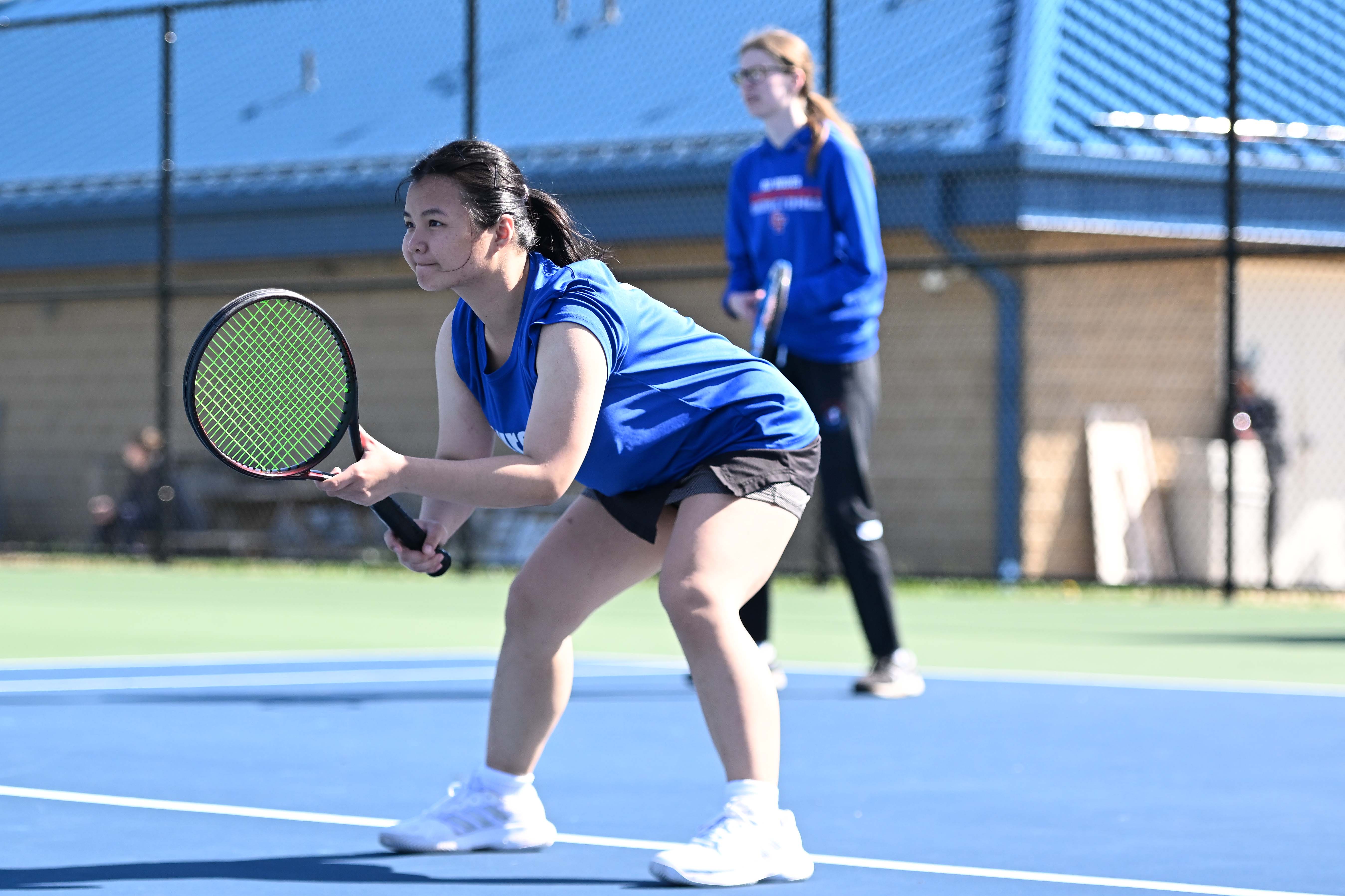 female tennis player waits on a serve from opponent
