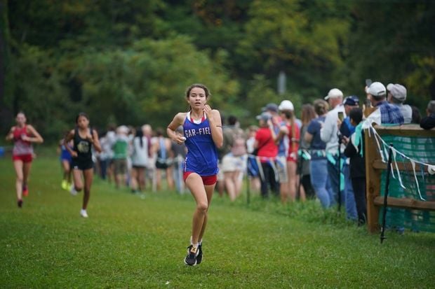 female athlete runs in a cross country race