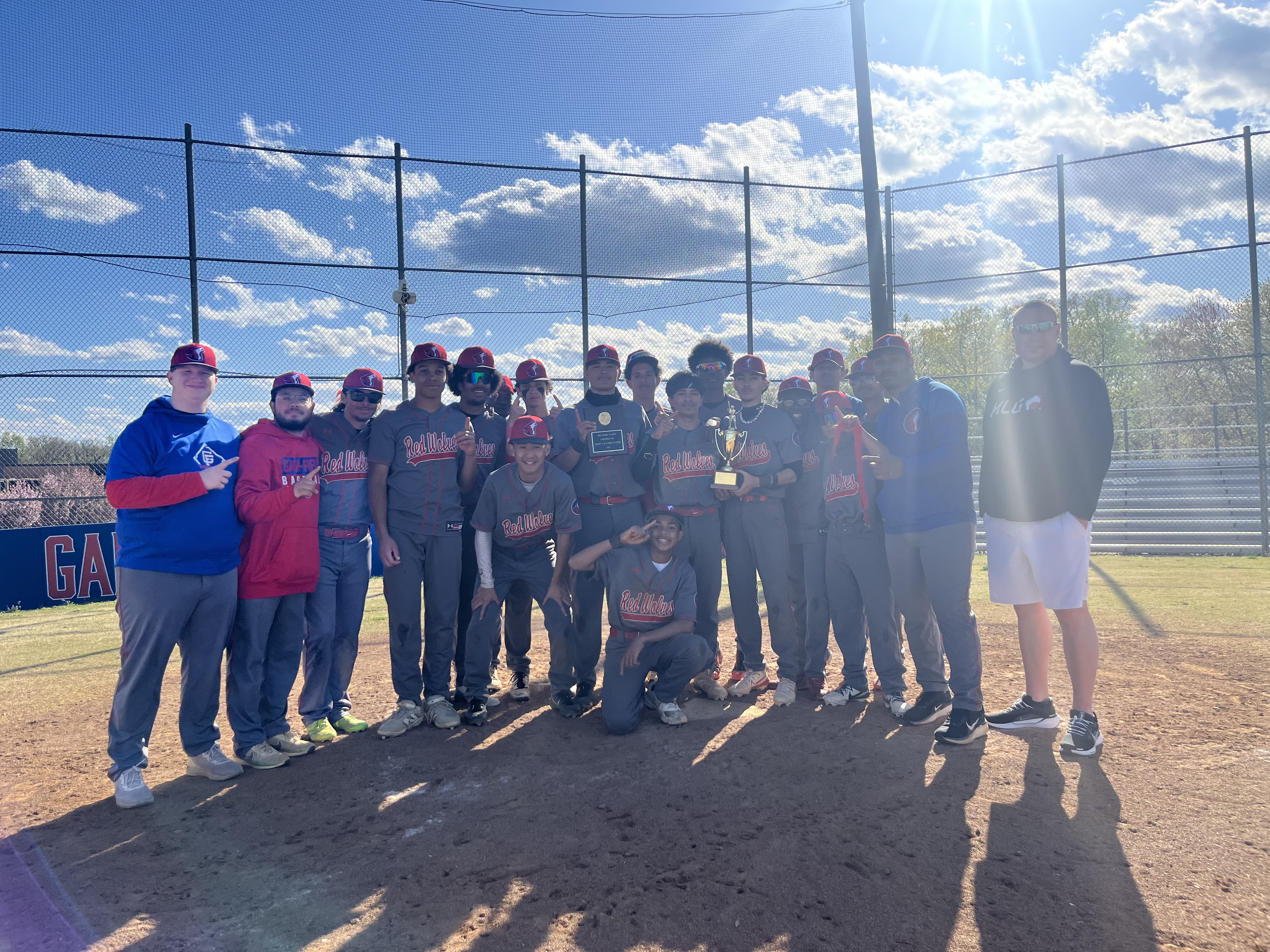 Baseball team picture with Alumni Jeff Baker and the Jeff Baker Classic trophy