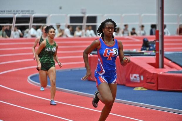 Female Student athlete running in an indoor track race